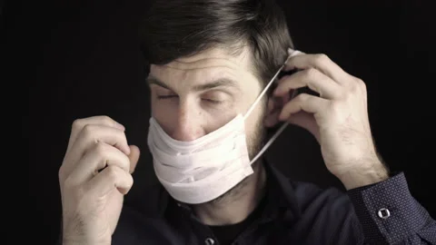 Man puts on a mask. Rules for putting on a face mask. Respiratory protection Stock Footage 140802426