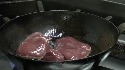 A man puts meat on a frying pan - closeup Stock Footage 82682253