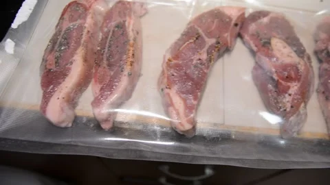 Man puts meat in a vacuum sealer film Vídeos de archivo 130371909