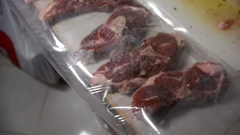 Man puts meat in a vacuum sealer film Stock Footage 130371914