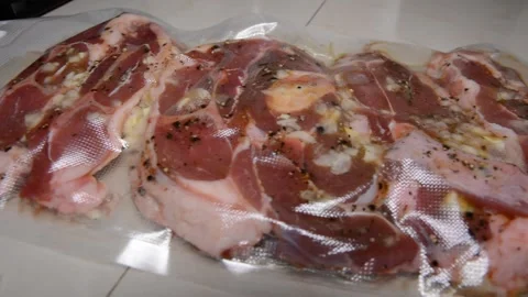 Man puts meat in a vacuum sealer film Vídeos de archivo 130371925