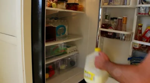 Man puts milk in fridge Stock Footage 12670296