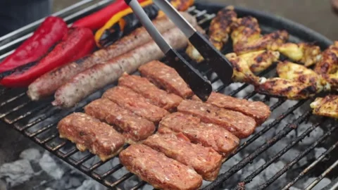 A man puts minced cutlets on the grill with tongs. Stock Footage 253513439