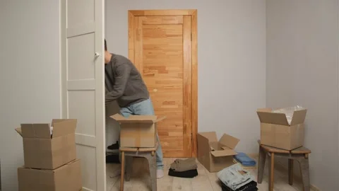 A man puts old clothes in a donation box with clothes. Help for the poor and Stock-Footage 303230616