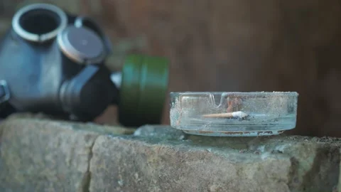 Man puts out a cigarette and takes a gas mask Stock Footage 196809661