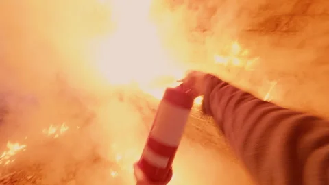 A man puts out a fire in an abandoned building with a powder fire extinguisher. Video stock 319778469