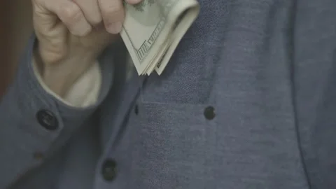 A man puts a pack of dollars in his jacket pocket. close-up video. Stock Footage 133123333