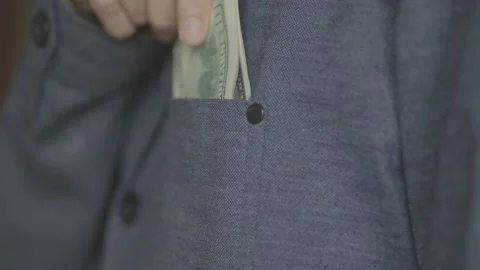 A man puts a pack of dollars in his jacket pocket. close-up video. Stock Footage 133123360