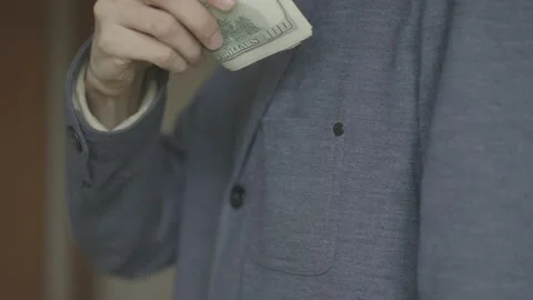 A man puts a pack of dollars in his jacket pocket. close-up video. Stock Footage 133123462