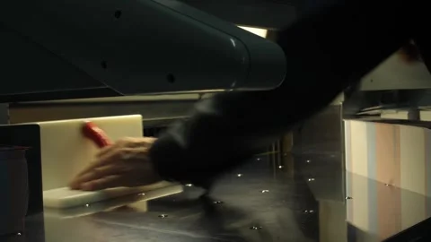 Man puts pack of flyers in automated cutting machine equipment in print house. Stock Footage 262545392