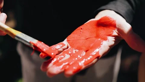 A man puts paint on his hand to leave an imprint on the overall picture Stock Footage 301210239