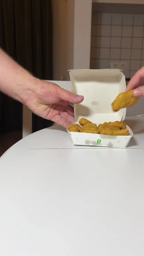 Man puts paper box with yellow McDonald's logo with chicken nuggets Stock Footage 299840068