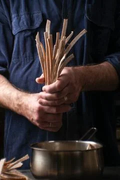 Man puts the paste in a saucepan for cooking Foto stock