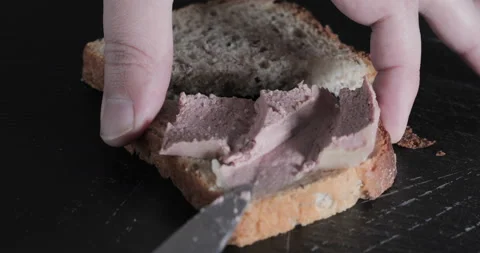 Man puts pate with the knife on a slice of bread Stock Footage 144830392