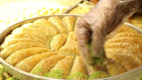 Man puts peanuts on top of baklava slices Stock Footage 82041587