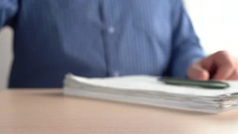 Man Puts A Pen On A Stack Of Papers And Takes A Mug Of Drink. Stock Footage 167887155