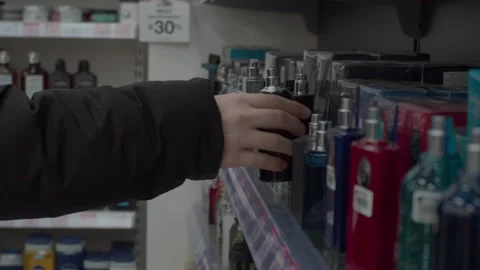 The man puts the perfume back in its place. Stock Footage 265573608