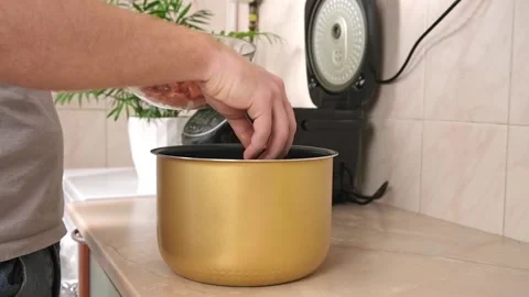 The man puts the pickled cut meat into the bowl of slow cooker. Fast cooking. Stock Footage 233470169