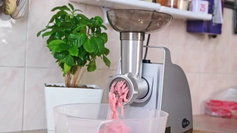 A man puts piece meat into electric meat grinder. Preparation minced beef, pork Stock Footage 204876589