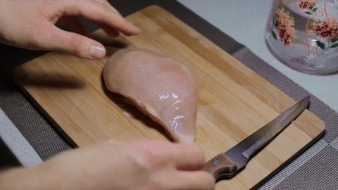 Man puts a piece of raw chicken meat on a cutting board, cooking at home Stock Footage 127650477