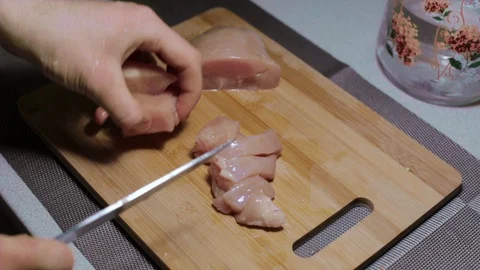 Man puts a piece of raw chicken meat on a cutting board, cooking at home Stock Footage 127650553