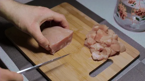 Man puts a piece of raw chicken meat on a cutting board, cooking at home Stock Footage 127650601