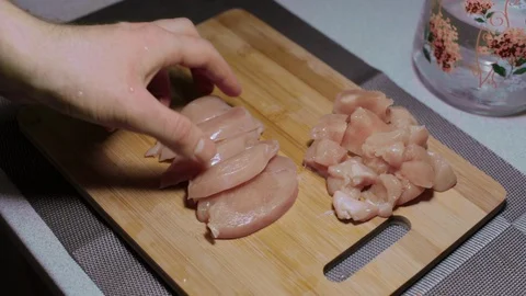 Man puts a piece of raw chicken meat on a cutting board, cooking at home Stock Footage 127650625
