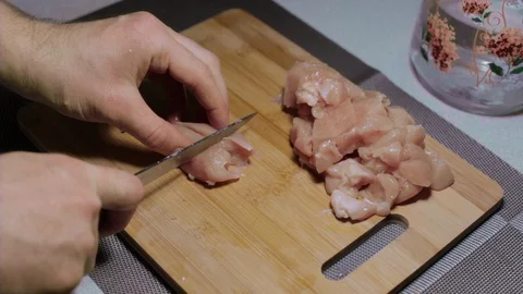Man puts a piece of raw chicken meat on a cutting board, cooking at home Stock Footage 127650670