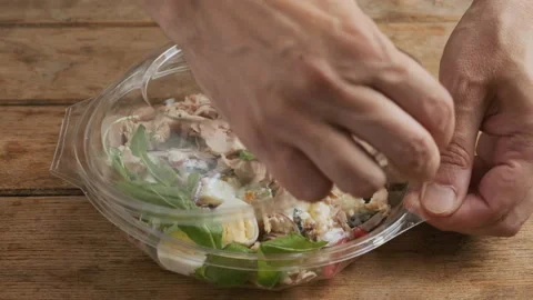Man puts plastic package with healthy baked ham salad for take away Stock Footage 218456900