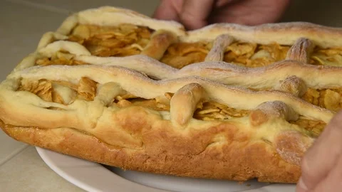 A man puts a plate of ready-made apple pie on the table. Stock Footage 145085805