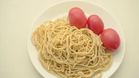The man puts the plate on the table and winds spaghetti with a fork. Stock Footage 159494315