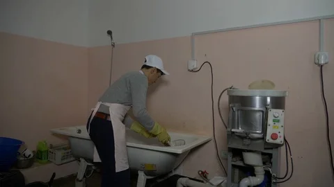 The man puts potatoes in a potato cleaner. Stock Footage 89609313
