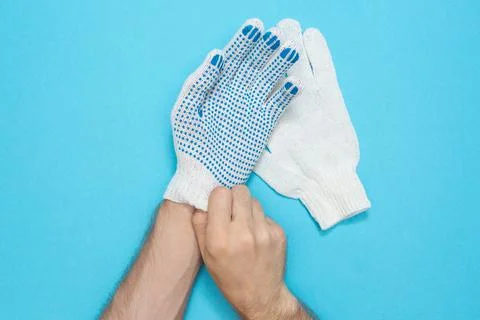 The man puts on protective construction gloves. Gloves made from durable fabric Foto stock