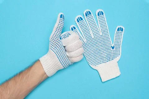 The man puts on protective construction gloves. Gloves made from durable fabric Stock Photos