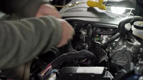 A man puts a protective cover on the wires and wraps insulating tape in the car Stock Footage 133729283