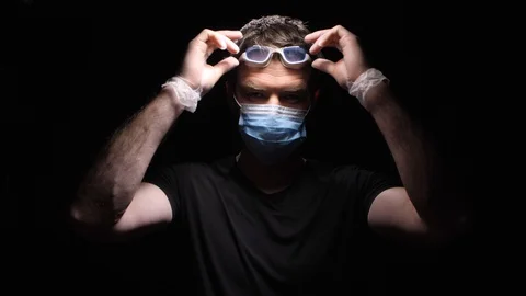 The man Puts on Protective Glasses and Threatens the Сovid-2019 Stock Footage 127865160