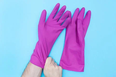 Man puts on protective rubber gloves. Purple gloves for cleaning. Flat lay Stock Photos