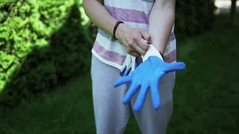 Man puts protective work gloves on his hands, prepare to garden work, work Video stock 246661946