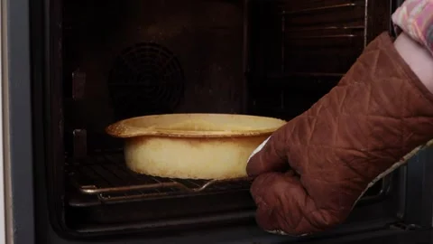 A man puts a pumpkin pie in the oven Video stock 286110537