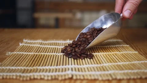 Man puts roasted coffee beans on table 库存影片 150402616