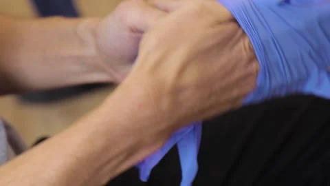 Man puts on rubber gloves 動画素材 164477443