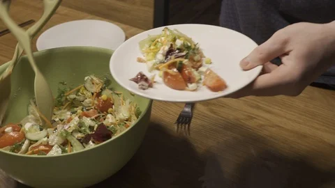Man puts salad in the plate Stock Footage 101662597