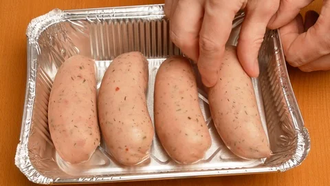 Man puts sausage in baking tray in the oven. Stock Footage 107730755