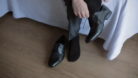 Man puts on shoes Stock Footage 97529197