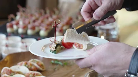 A man puts snacks on a plate 스톡 동영상 274836153