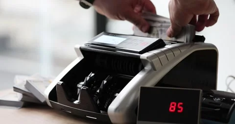 Man puts stack of dollar banknotes into bill counter Stock Footage 278969439