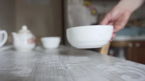 Man puts on the table a plate and a spoon Stock Footage 131984808
