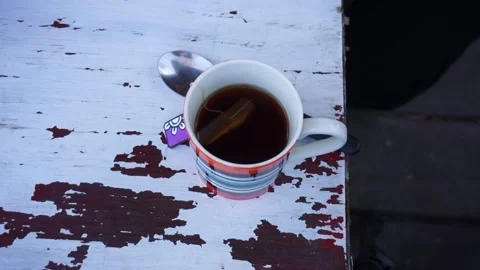 Man puts tea down in a wooden table Stock Footage 196447744
