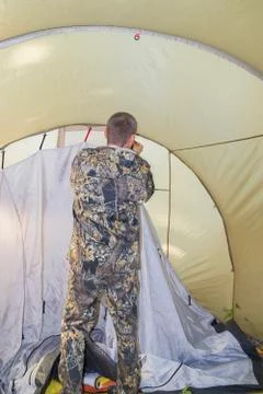 A man puts up a tent on the site of a future camp in the forest Stock Photos