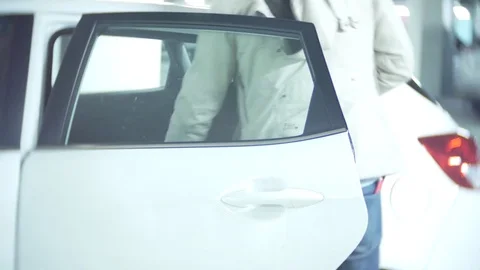 A man puts things in the car and sits behind the wheel. 4k Stock Footage 84699559